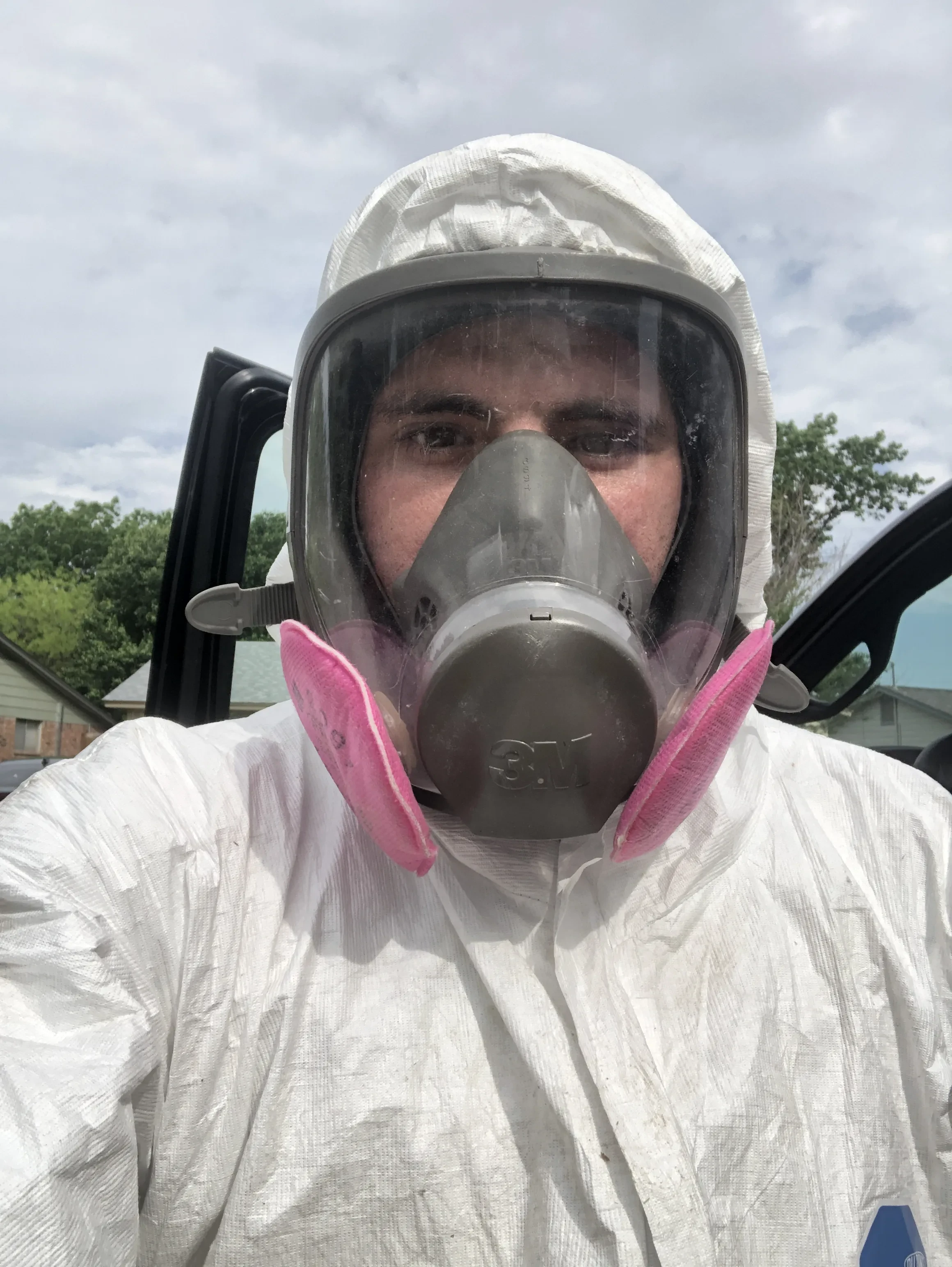 Superior Attic technician in a protective suit and respirator on an insulation removal job