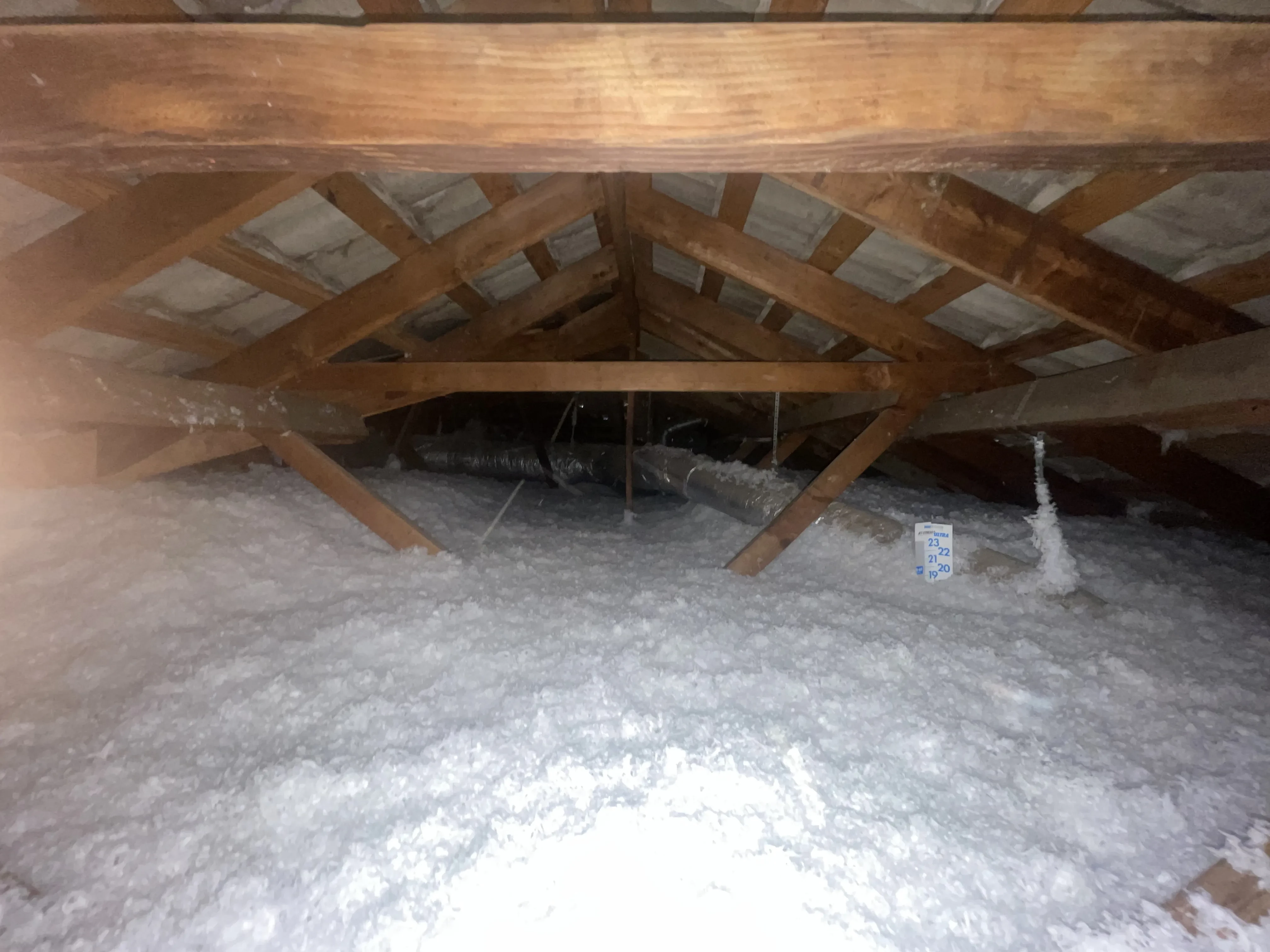 Blown-in fiberglass insulation installed to an even depth across an attic floor